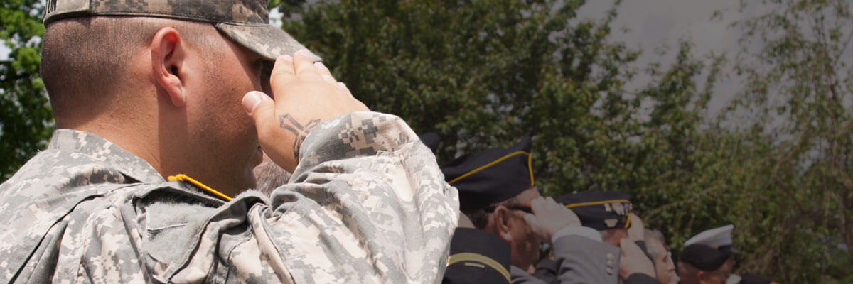 Army veteran in combat fatigues saluting