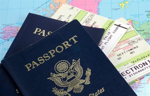 Two passports in front of a map and plane ticket